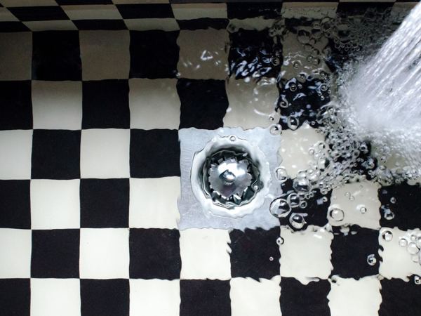 Kitchen sink filling with water above a slow drain